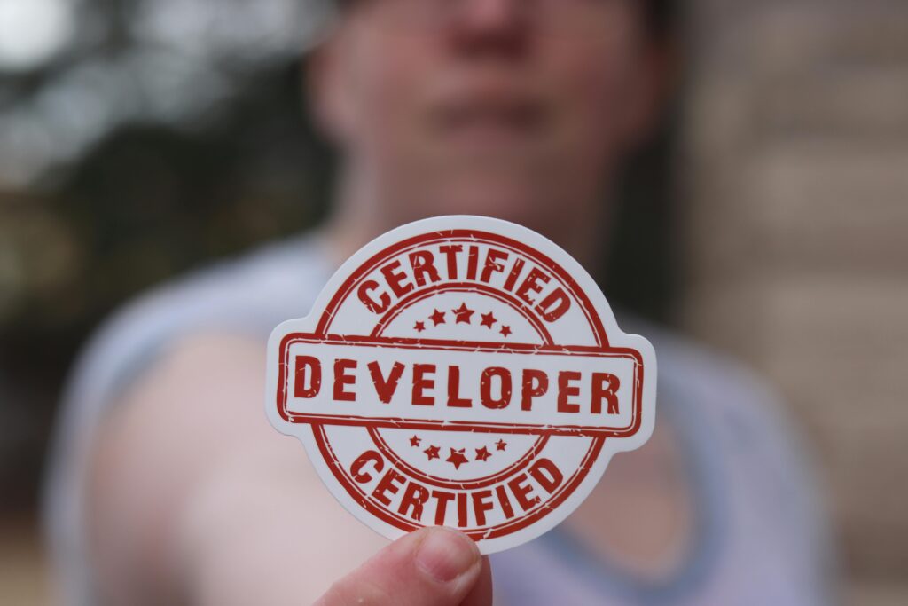 Close-up of a certified developer badge being held outdoors.